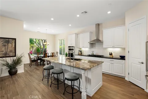 a kitchen with a dining table chairs stainless steel appliances and cabinets
