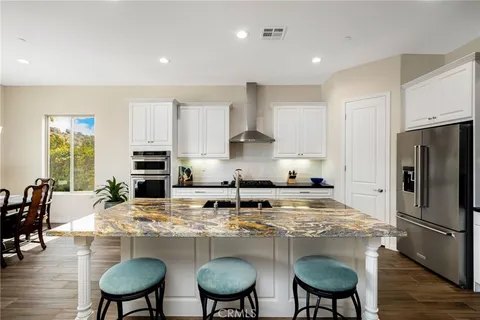 a kitchen with refrigerator and chairs