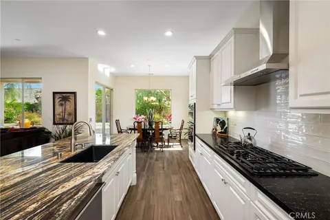 a kitchen with granite countertop lots of counter top space a sink and stainless steel appliances