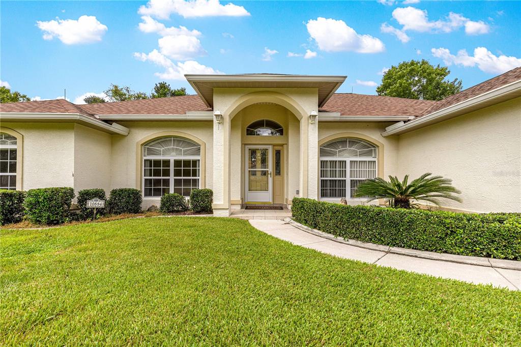 10884 Southwest 53rd Circle Ocala, FL 34476 - Photo 2 of 57 a front view of a house with a yard