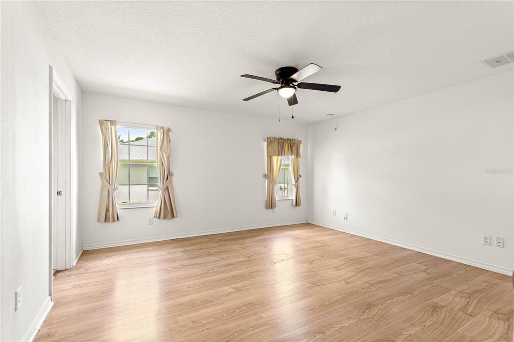10884 Southwest 53rd Circle Ocala, FL 34476 - Photo 23 of 57 a view of room with hardwood floor and ceiling fan