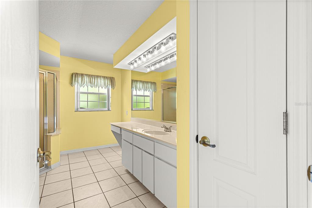 10884 Southwest 53rd Circle Ocala, FL 34476 - Photo 26 of 57 a bathroom with a sink a mirror and a shower