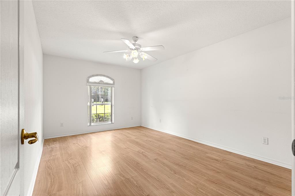 10884 Southwest 53rd Circle Ocala, FL 34476 - Photo 34 of 57 an empty room with wooden floor fan and windows