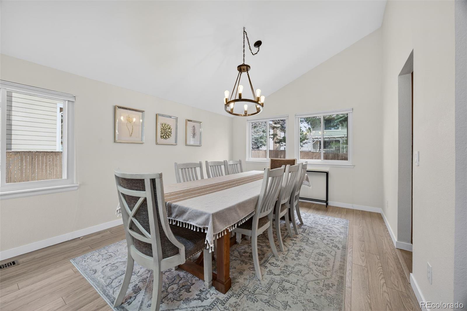 8764 Wildrose Court Highlands Ranch, CO 80126 - Photo 23 of 50 a dining room with furniture a chandelier and wooden floor