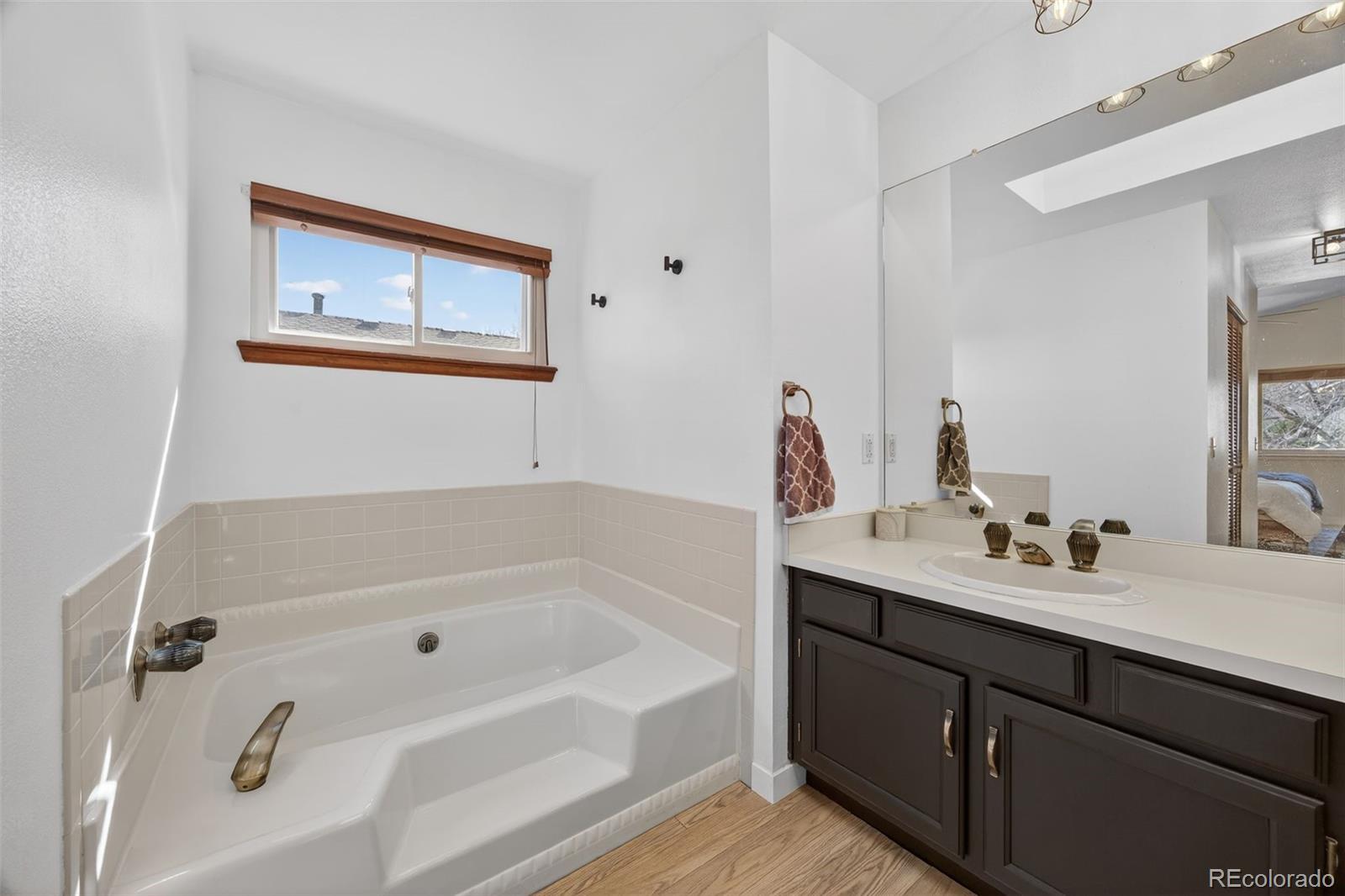8764 Wildrose Court Highlands Ranch, CO 80126 - Photo 37 of 50 a bathroom with a tub sink and mirror