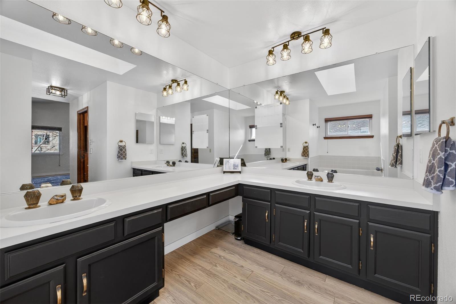 8764 Wildrose Court Highlands Ranch, CO 80126 - Photo 38 of 50 a bathroom with double vanity sinks a vanity a lamp and a mirror