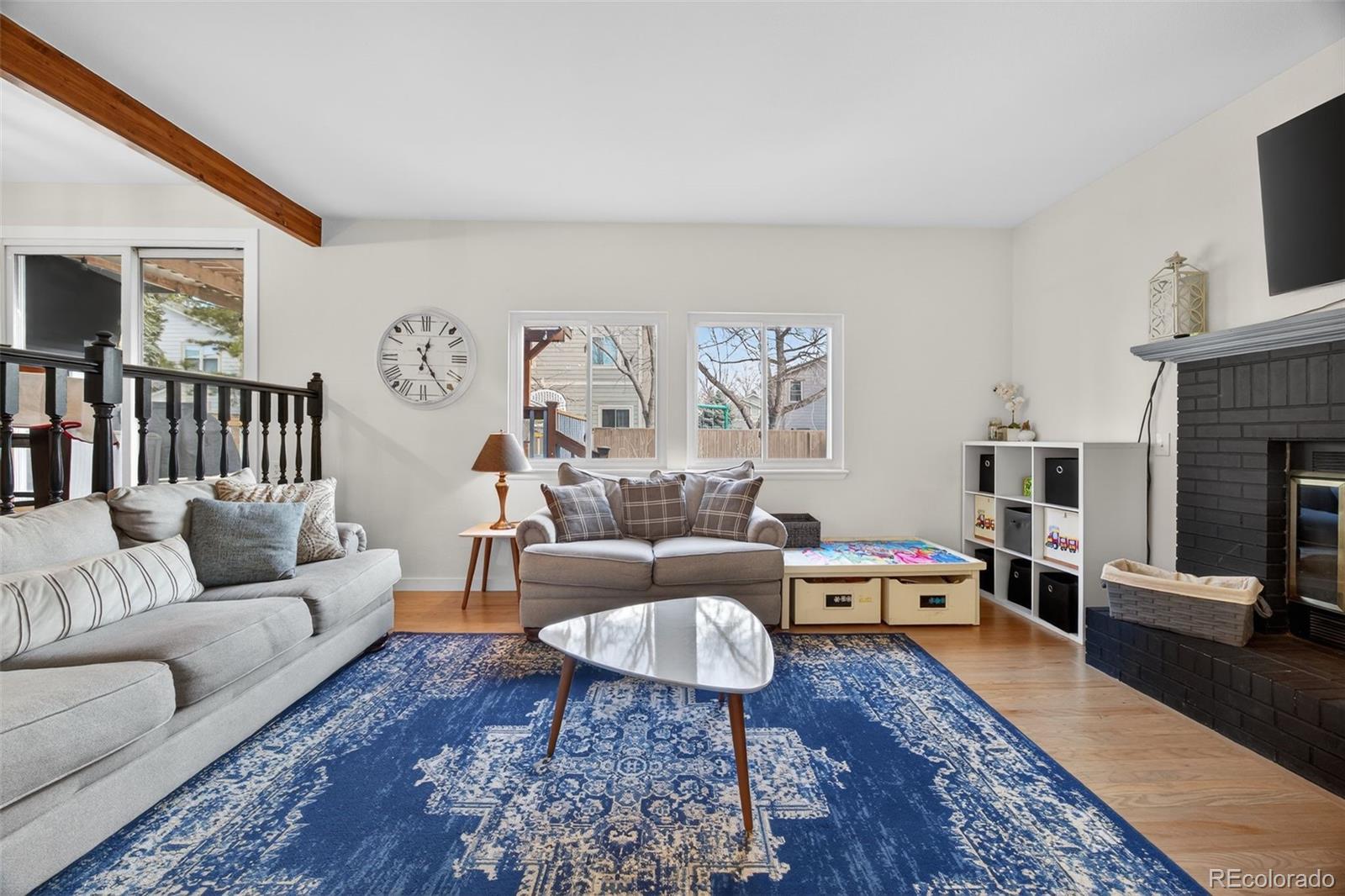 8764 Wildrose Court Highlands Ranch, CO 80126 - Photo 10 of 50 a living room with furniture and a fireplace