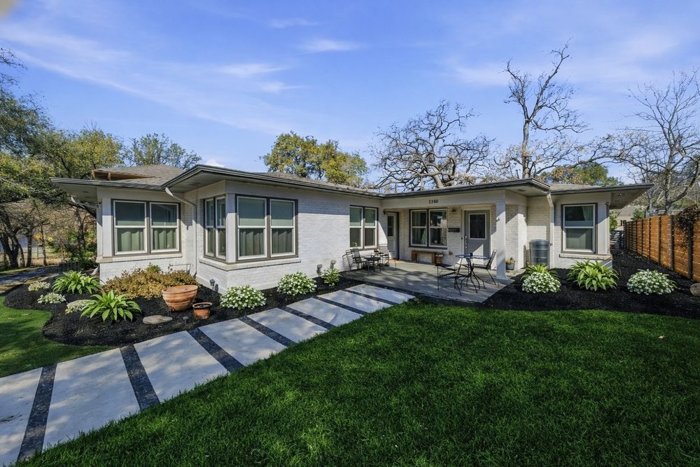 a front view of a house with garden and patio