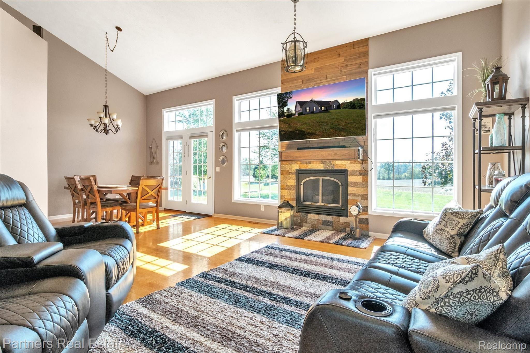 The Living Room boasts hardwood floors, a stunning gas fireplace, a vaulted ceiling and loads of light and views of the private backyard and stamped concrete patio!