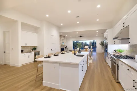 a large white kitchen with lots of counter space a sink and appliances