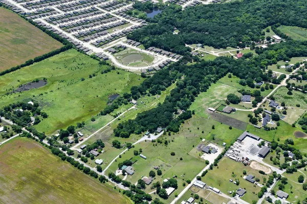an aerial view of a residential houses with yard