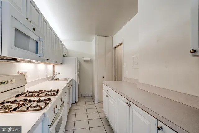 a kitchen with a cabinets and white appliances