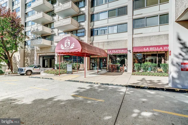 a front view of multi story building with retail shops