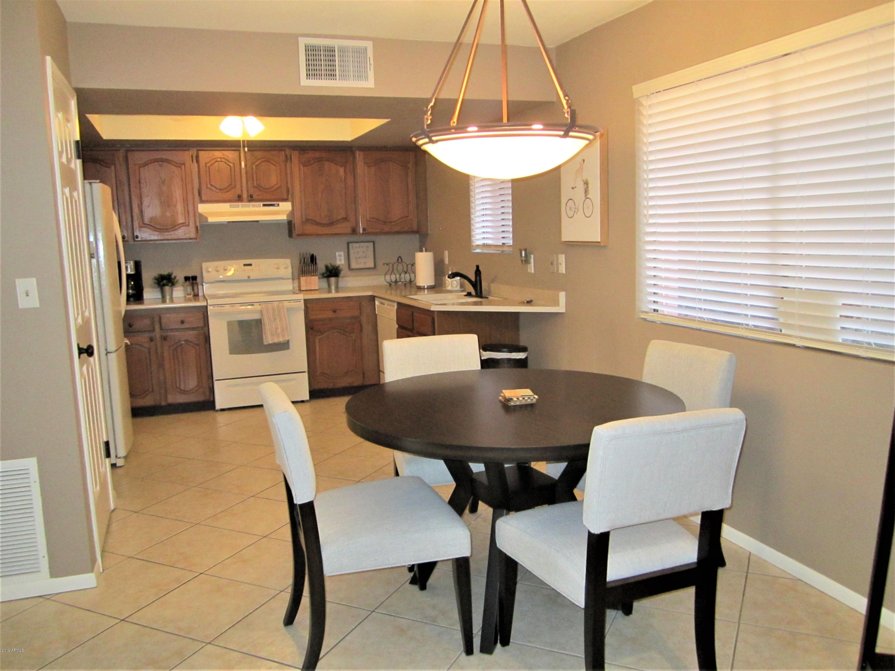4303 East Cactus Road, Unit 116 Phoenix, AZ 85032 - Photo 15 of 35 a dining room with a sink a table and chairs