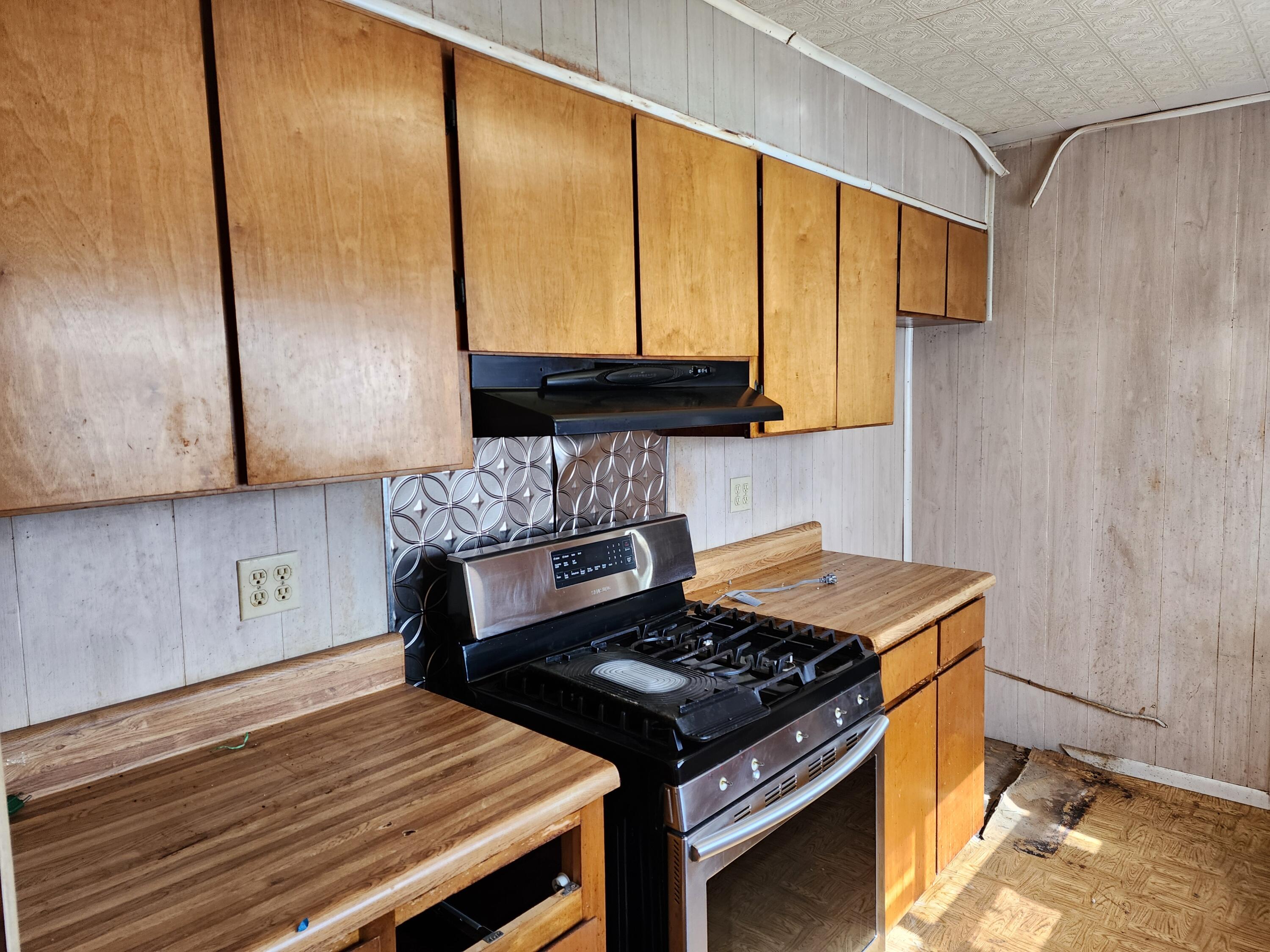 6181 Bethany Drive Crestview, FL 32539 - Photo 14 of 28 a kitchen with a stove and a wooden cabinets