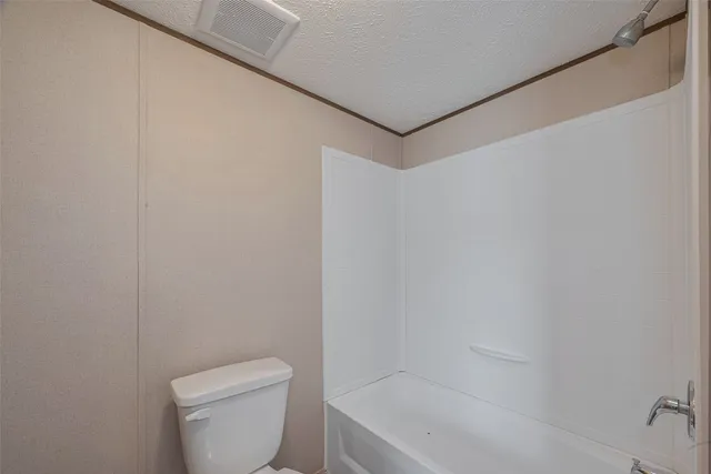 a white toilet sitting next to a bath tub