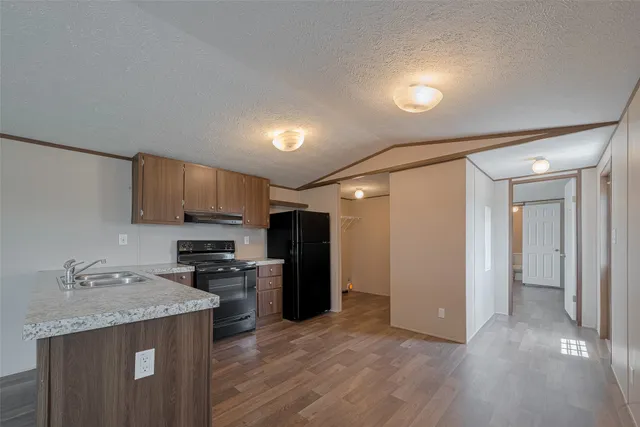 a kitchen with a sink a refrigerator and cabinets