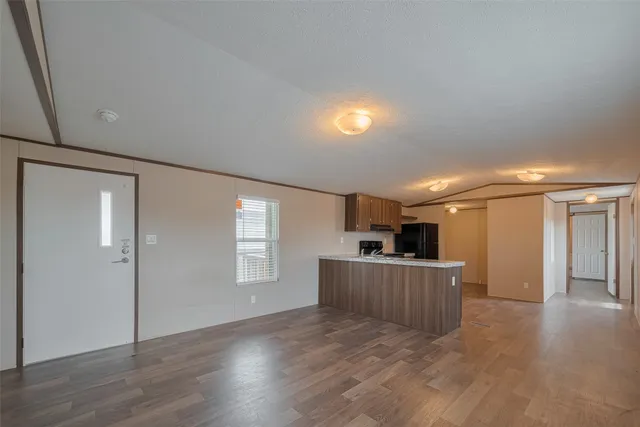 a view of a kitchen with furniture and wooden floor