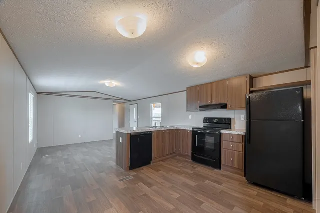 a kitchen with stainless steel appliances a refrigerator and a stove top oven