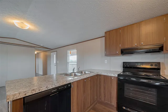 a kitchen with stainless steel appliances granite countertop a sink stove and cabinets