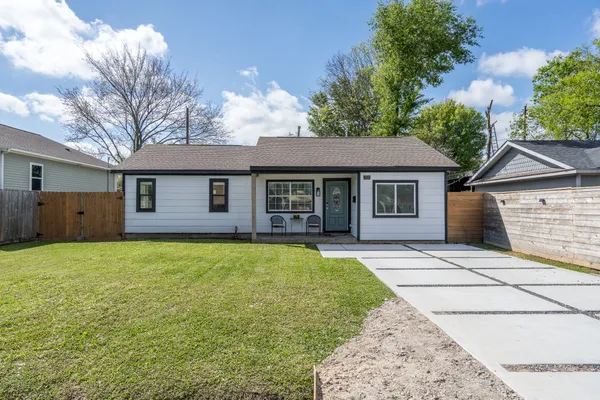 a front view of a house with a garden and yard