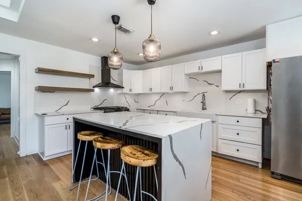 a kitchen with a stove a refrigerator and cabinets