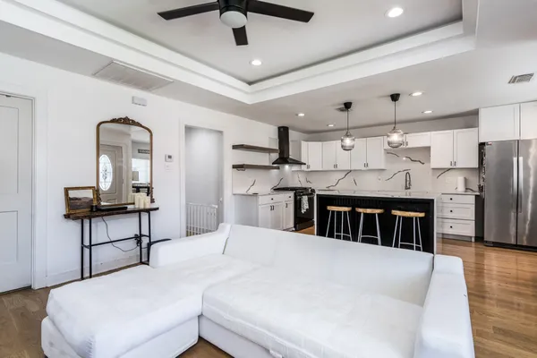 a kitchen with stainless steel appliances kitchen island granite countertop a table chairs in it and wooden floors