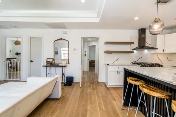 a kitchen with stainless steel appliances granite countertop a stove a sink dishwasher and a refrigerator with wooden floor