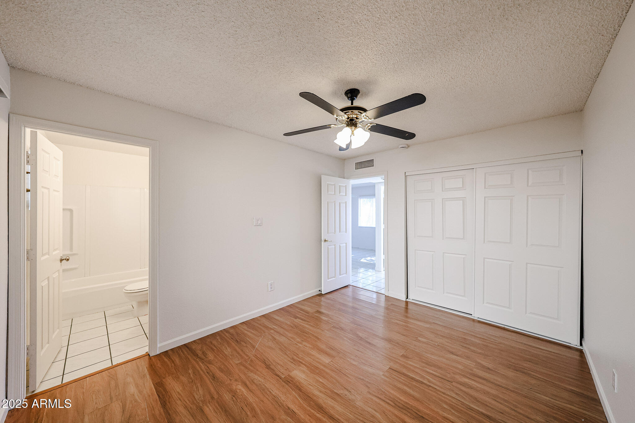 3408 West Port Au Prince Lane Phoenix, AZ 85053 - Photo 18 of 61 an empty room with wooden floor and windows