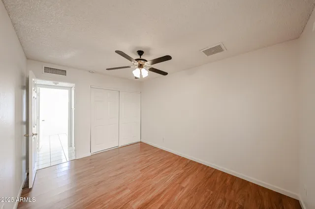 a large white kitchen with a stove a sink dishwasher and a refrigerator with wooden floor