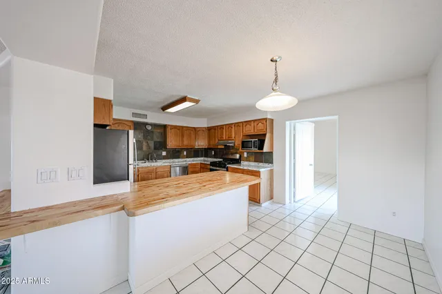 a kitchen with stainless steel appliances granite countertop a sink refrigerator and microwave