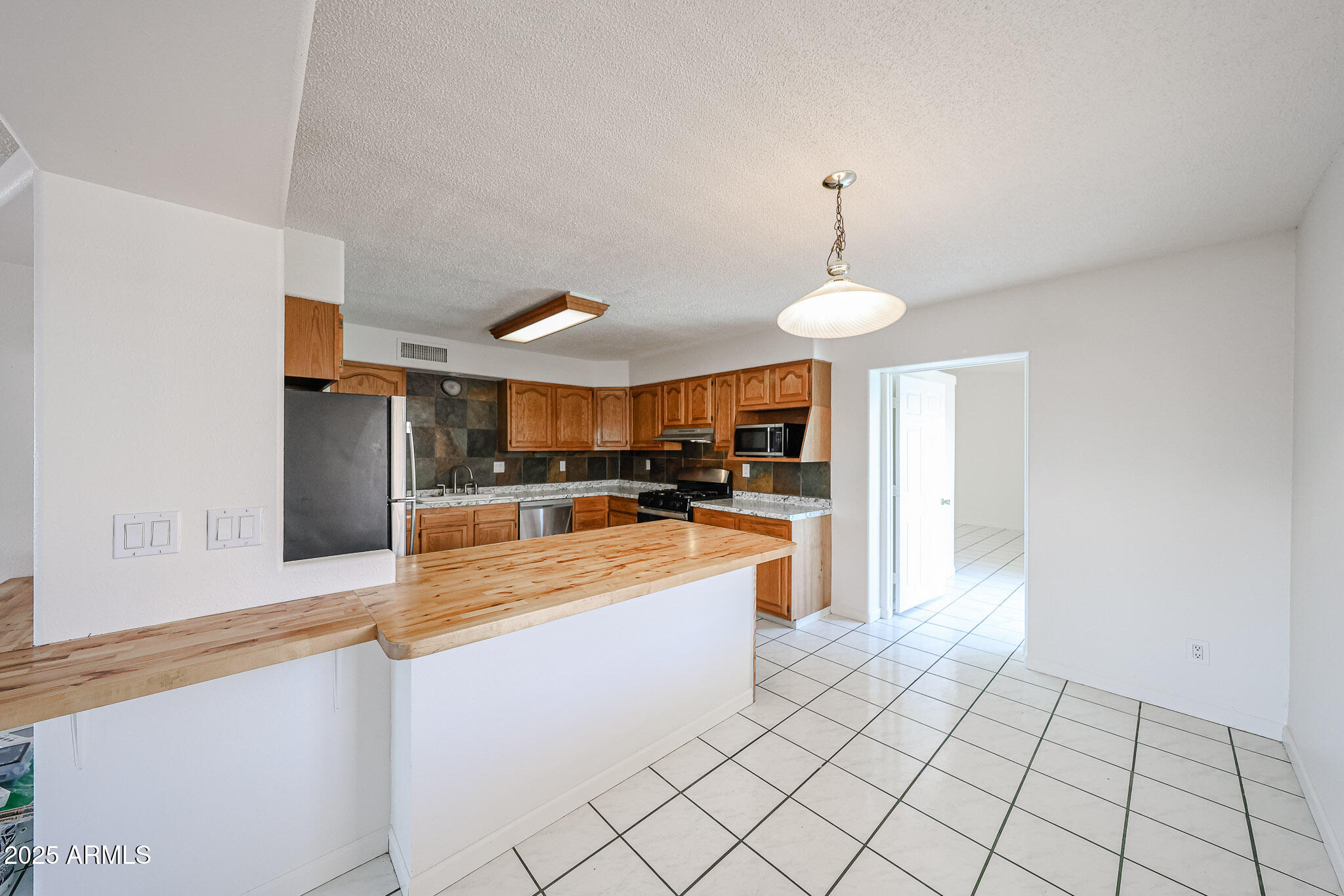 3408 West Port Au Prince Lane Phoenix, AZ 85053 - Photo 22 of 61 a large kitchen with cabinets and stainless steel appliances