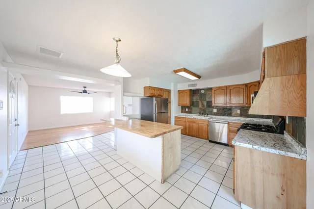 a kitchen with a refrigerator a stove top oven and cabinets