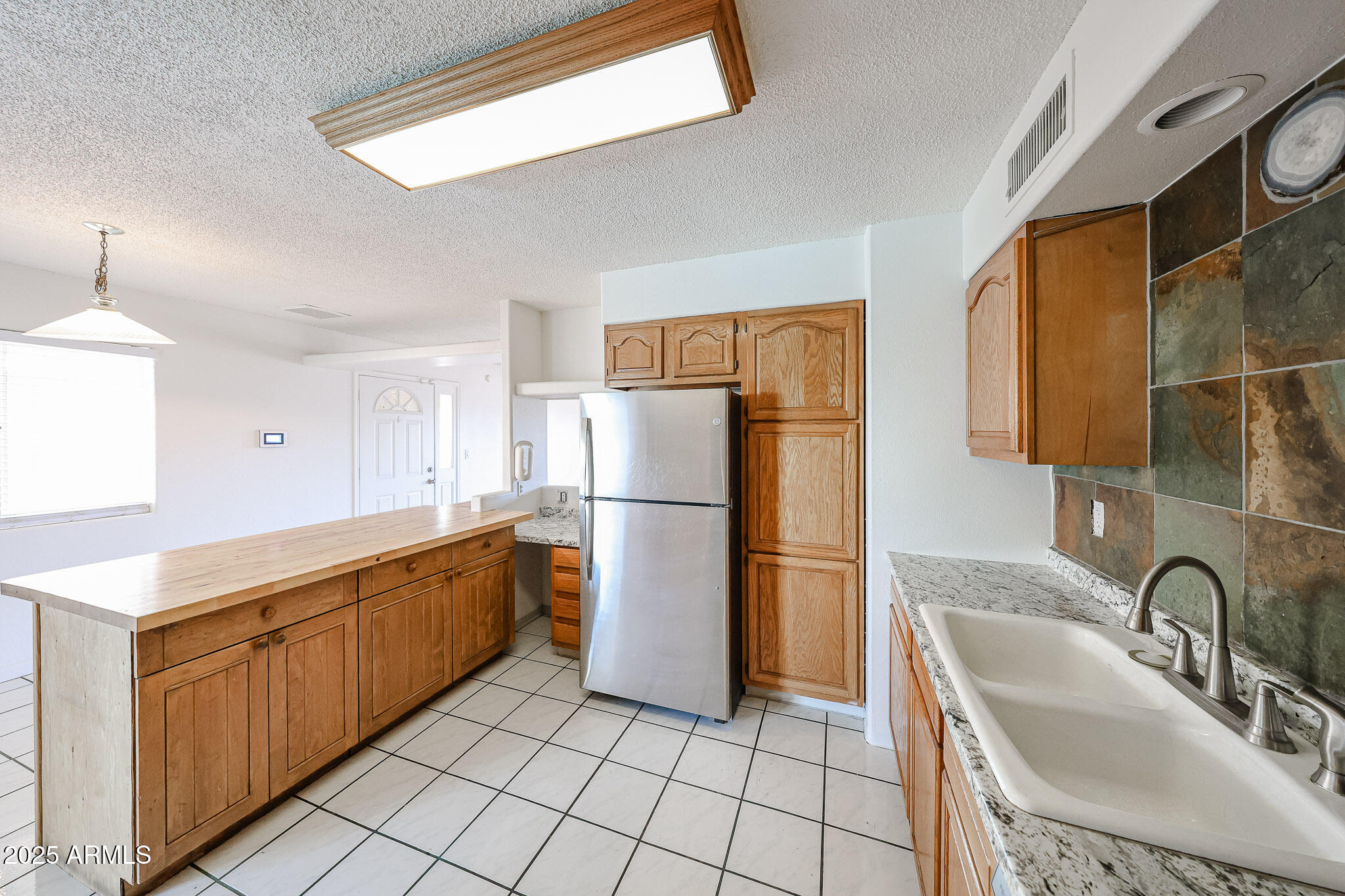 3408 West Port Au Prince Lane Phoenix, AZ 85053 - Photo 25 of 61 a kitchen with stainless steel appliances granite countertop a sink refrigerator and microwave