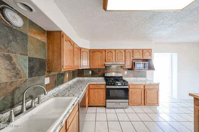a kitchen with stainless steel appliances granite countertop a stove sink and cabinets