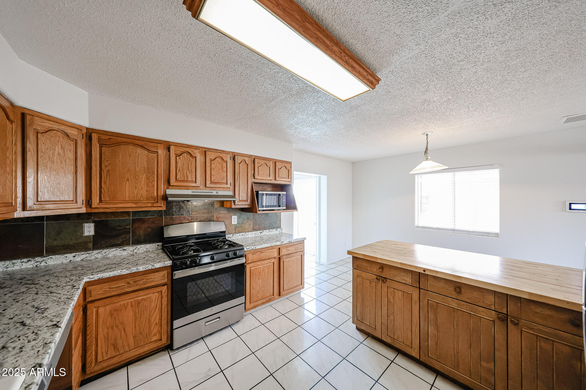 3408 West Port Au Prince Lane Phoenix, AZ 85053 - Photo 29 of 61 a kitchen with stainless steel appliances granite countertop a stove a sink and a granite counter tops