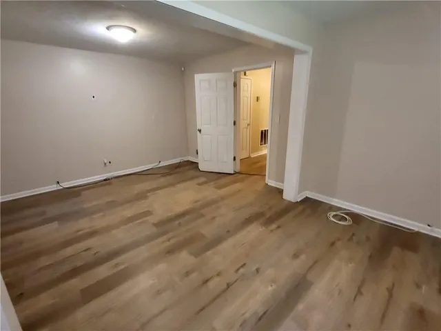 an empty room with wooden floor and closet