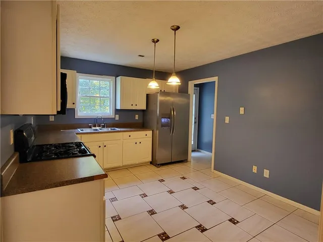 a kitchen with a sink a stove a refrigerator and cabinets