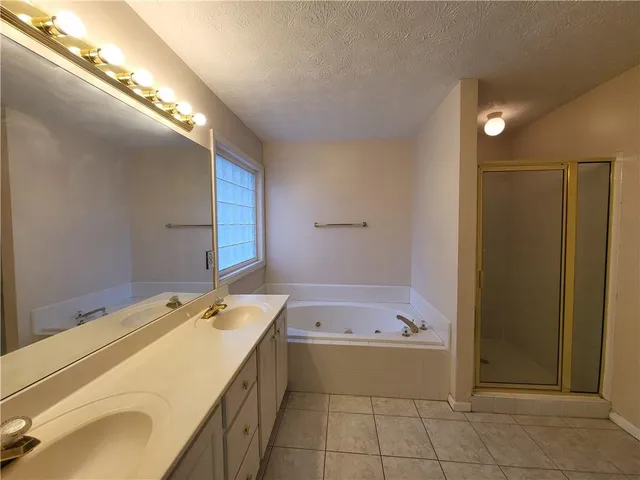 a bathroom with a tub sink and mirror