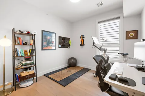 a view of a workspace with furniture and a window