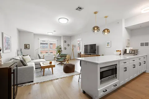 a living room with furniture a flat screen tv and kitchen view