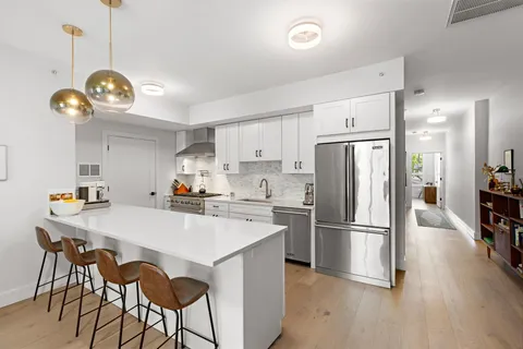 a kitchen with refrigerator cabinets and wooden floor