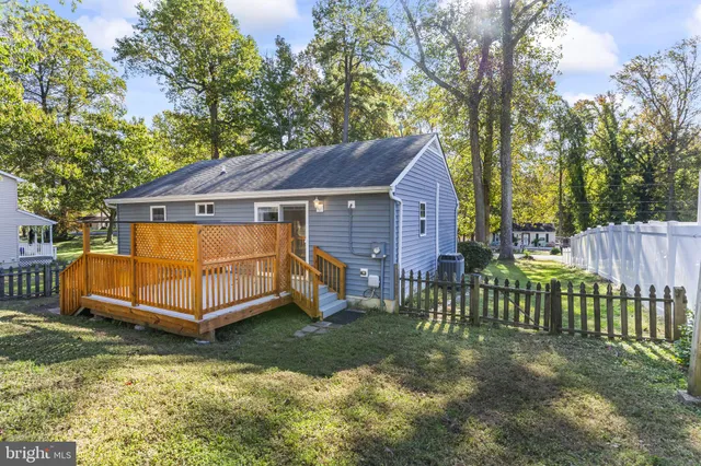 a view of a house with a yard wooden fence and a large tree