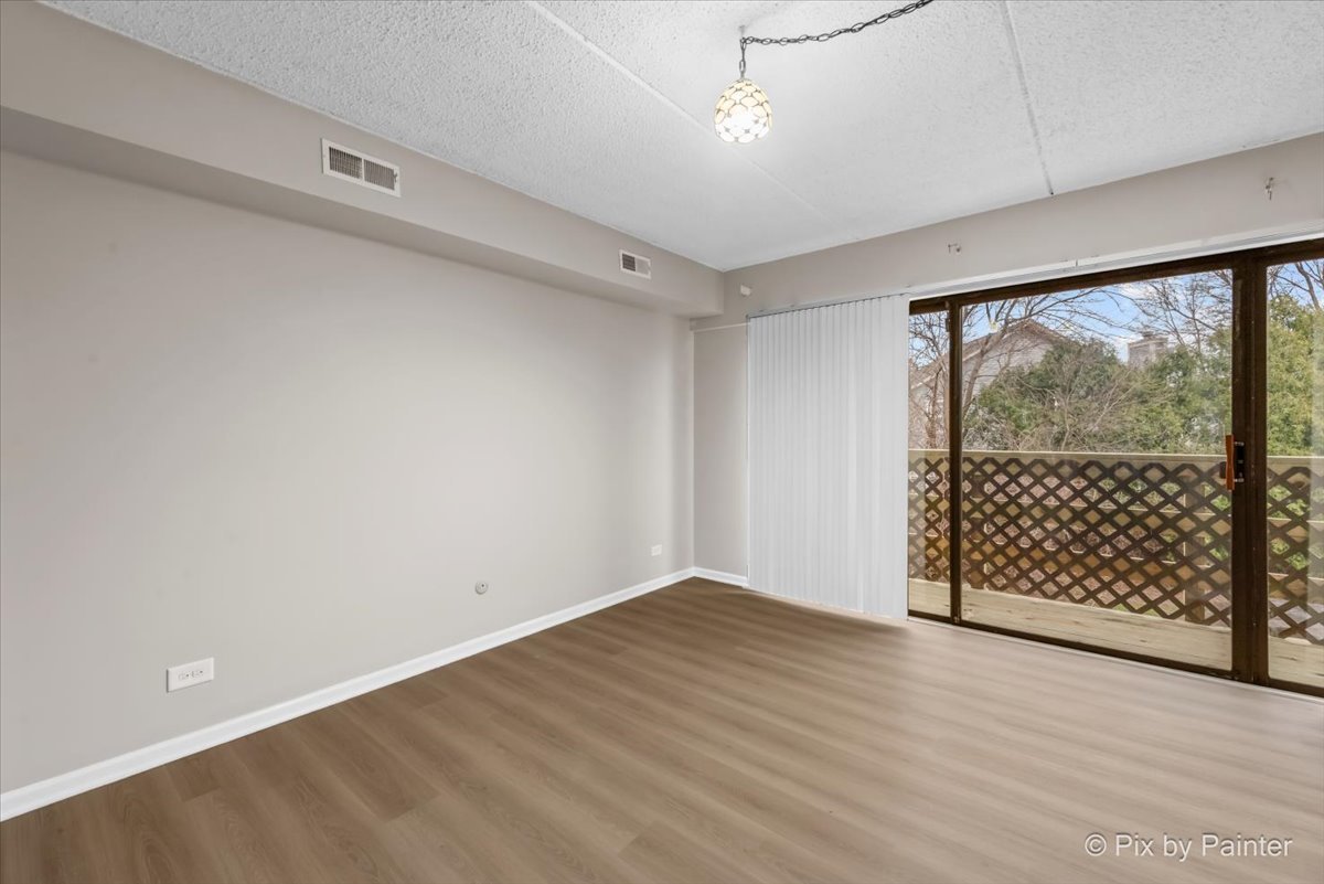 712 Kenneth Circle Elgin, IL 60120 - Photo 14 of 27 an empty room with wooden floor and windows