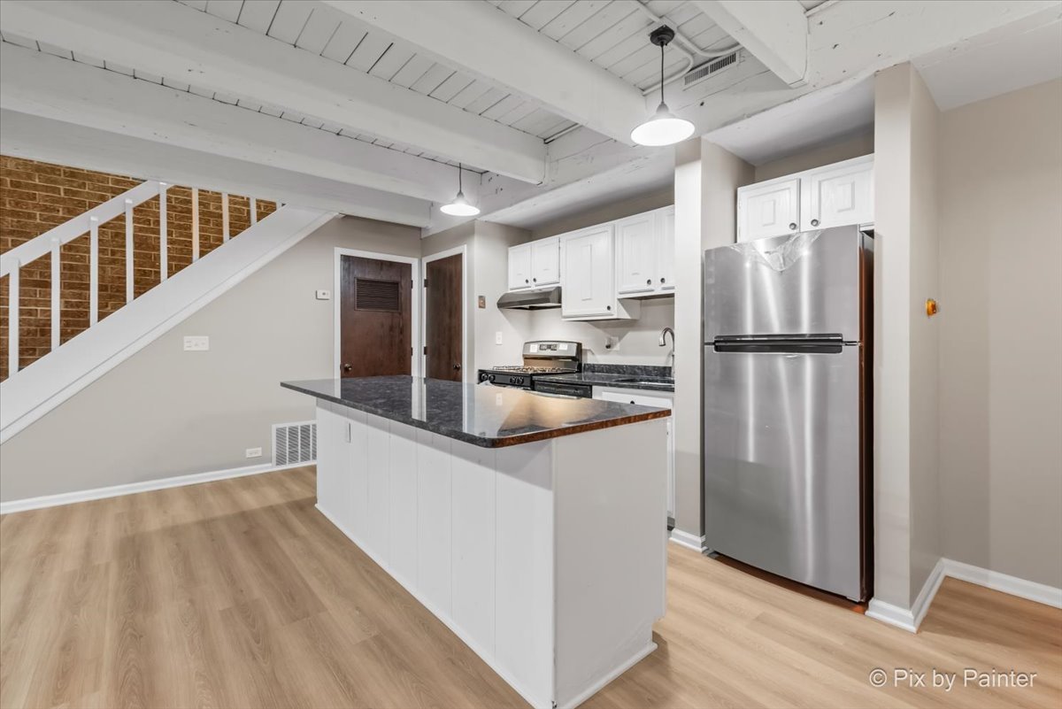 712 Kenneth Circle Elgin, IL 60120 - Photo 6 of 27 a kitchen with stainless steel appliances a refrigerator and a stove top oven