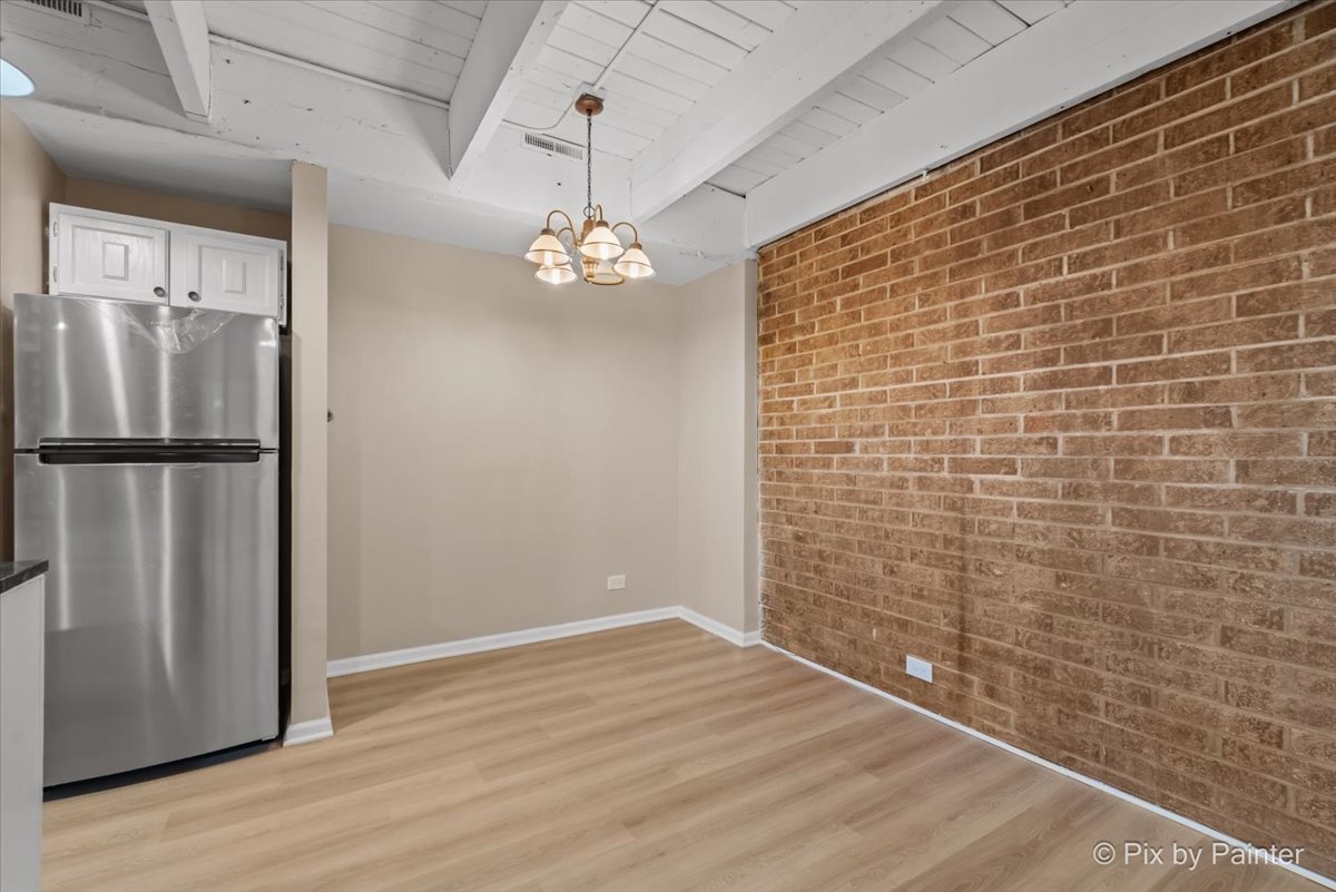712 Kenneth Circle Elgin, IL 60120 - Photo 10 of 27 a view of empty room with wooden floor and chandelier