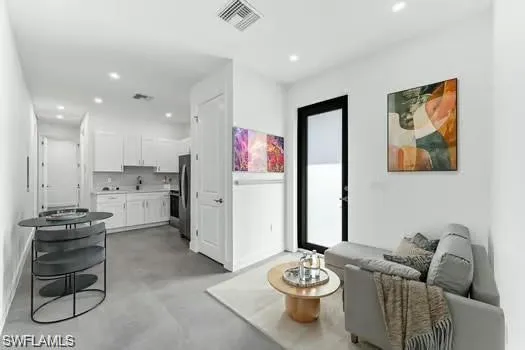 a living room with furniture and kitchen view