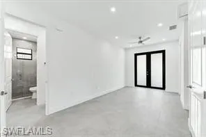 a view of a hallway with wooden floor and a bathroom