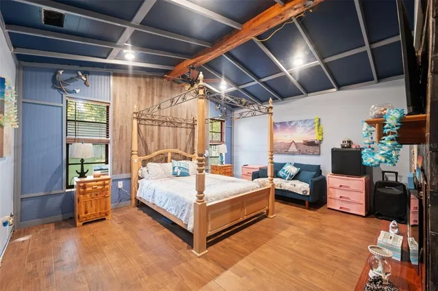 a spacious bedroom with a bed and a chandelier