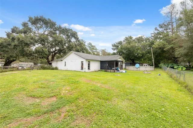 a front view of house with yard and trees in the background